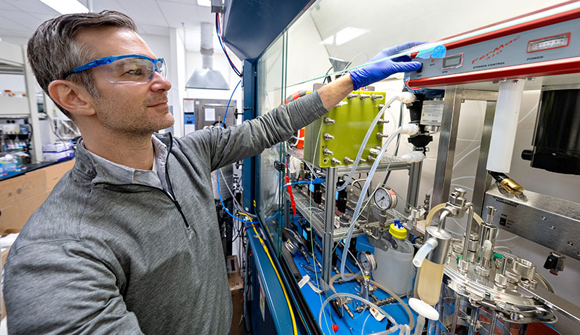 carbon-management-utilization-research-75213 One researcher with safety glasses working in equipment in a lab.
