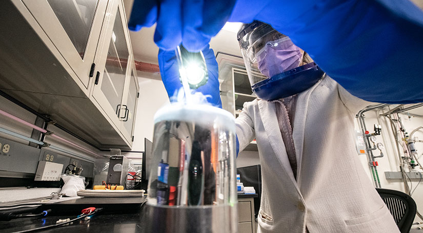 science-of-biological-energy-conversion-research-63695 One researcher with safety glasses and a face mask working on equipment in a lab.