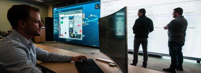 61069 Researchers visualize a real-time cyberattack projected onto wall-size screens.