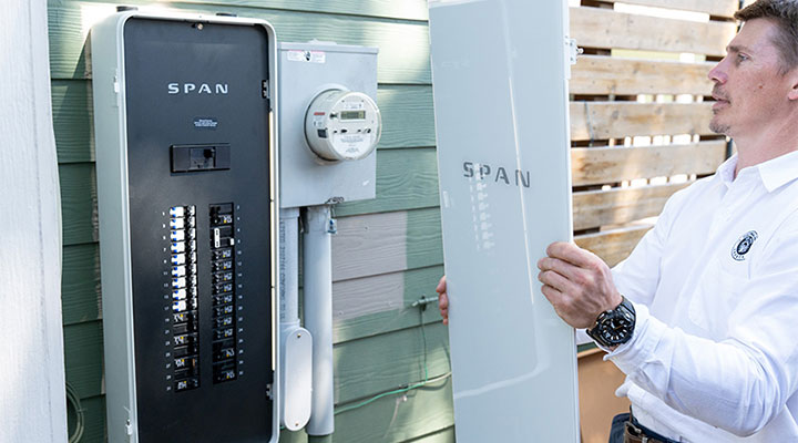Person installs breaker panel on house