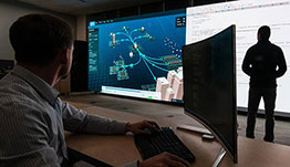 cybersecurity-resilience-61071-cap Researchers view large projections of a cyber attack from a computer.