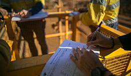 regulatory-permitting-istock-1184970341-cap Hand filling out form at safety site.