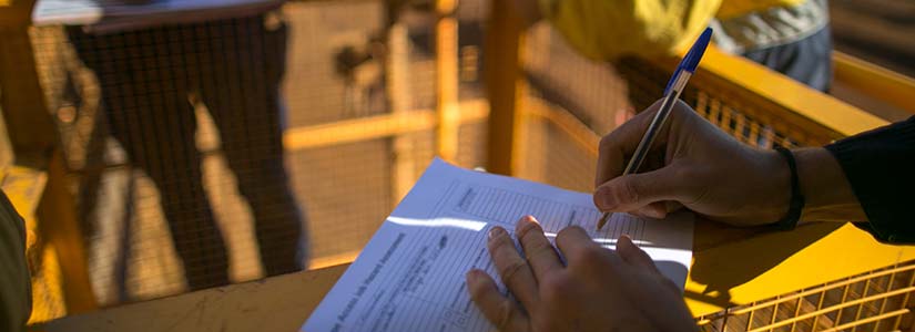 regulatory-permitting-istock-1184970341 Hand filling out form at safety site.