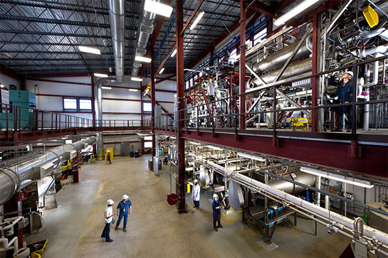 photo-ibrf-interior-20248 Photo of a large, warehouse-like, lab space with several people in hard hats operating equipment.