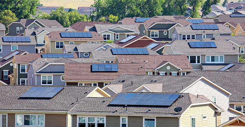 Photo of a neighborhood of single-family homes with solar panels installed on each.