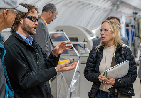 20250515-updated-risk-management-framework-supports-success-of-marine-energy-devices-73871 Three people talking in a lab.