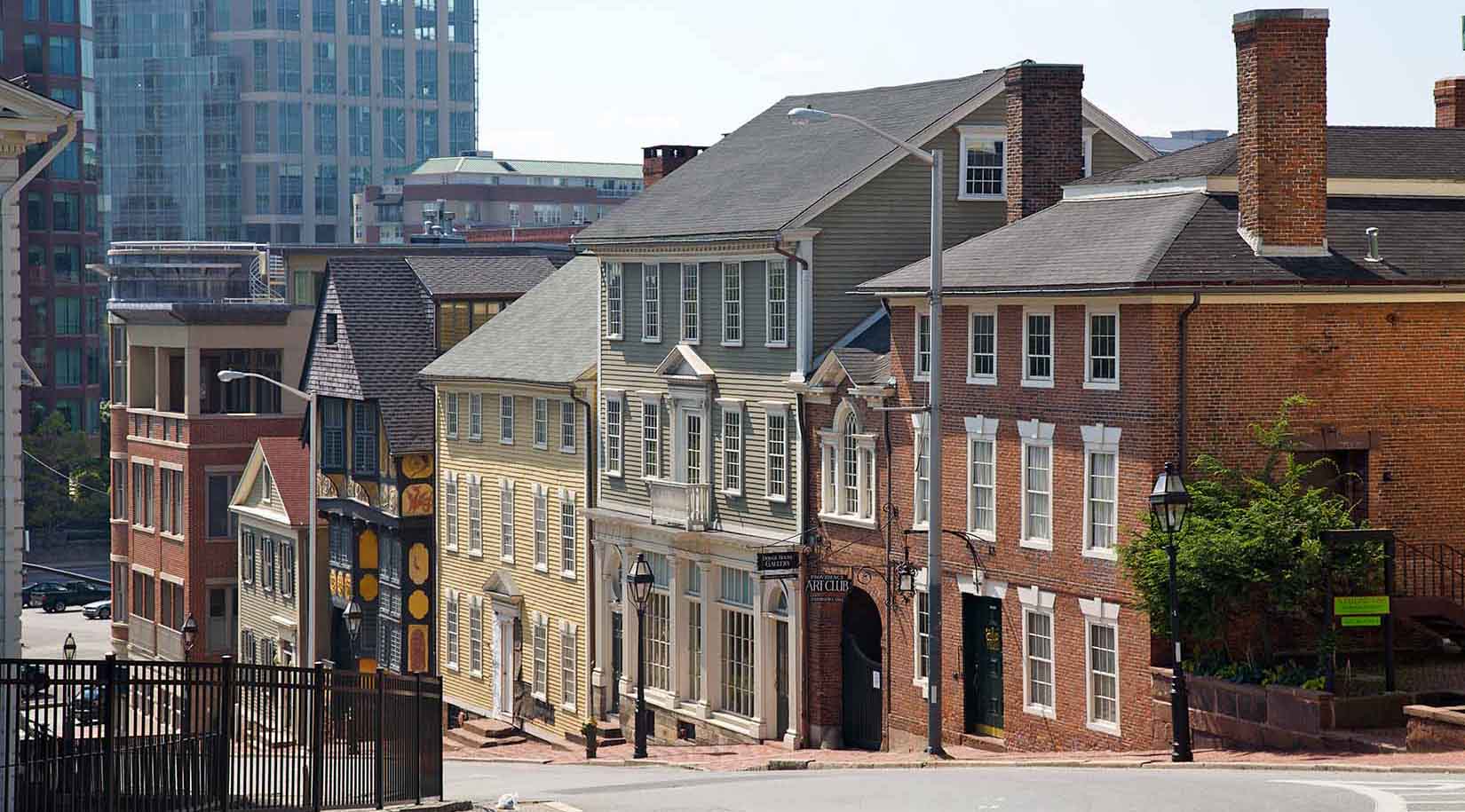 Different buildings sloping down a hill in a big city.