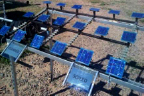 Photograph showing three rows of blue square solar panels. Panels in left portion are labeled 